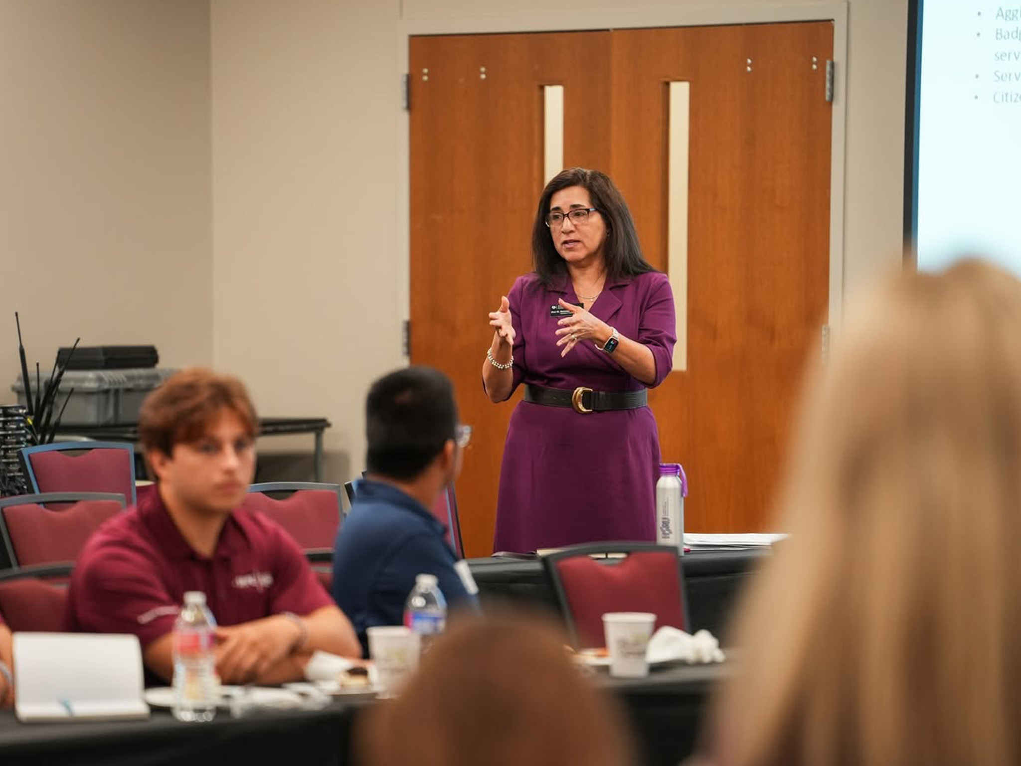 Dr. Gonzalez speaking to seated attendees in a conference room during the Lunch and Learn.